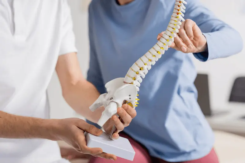 Spine Surgeon Showing a Patient a Model of a Herniated Disc in South Florida