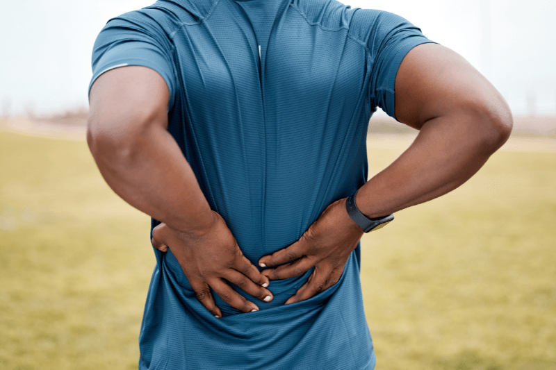 A Man with Back Pain Holds His Back in South Florida